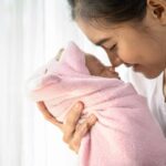newborn-baby-sleeping-hands-mother-nose-collided-750x536
